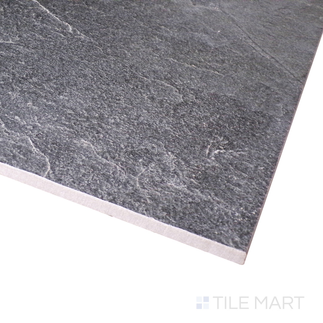 Captured at an angle, this matte porcelain tile reveals the depth of its rich black hue with a smooth, refined finish.