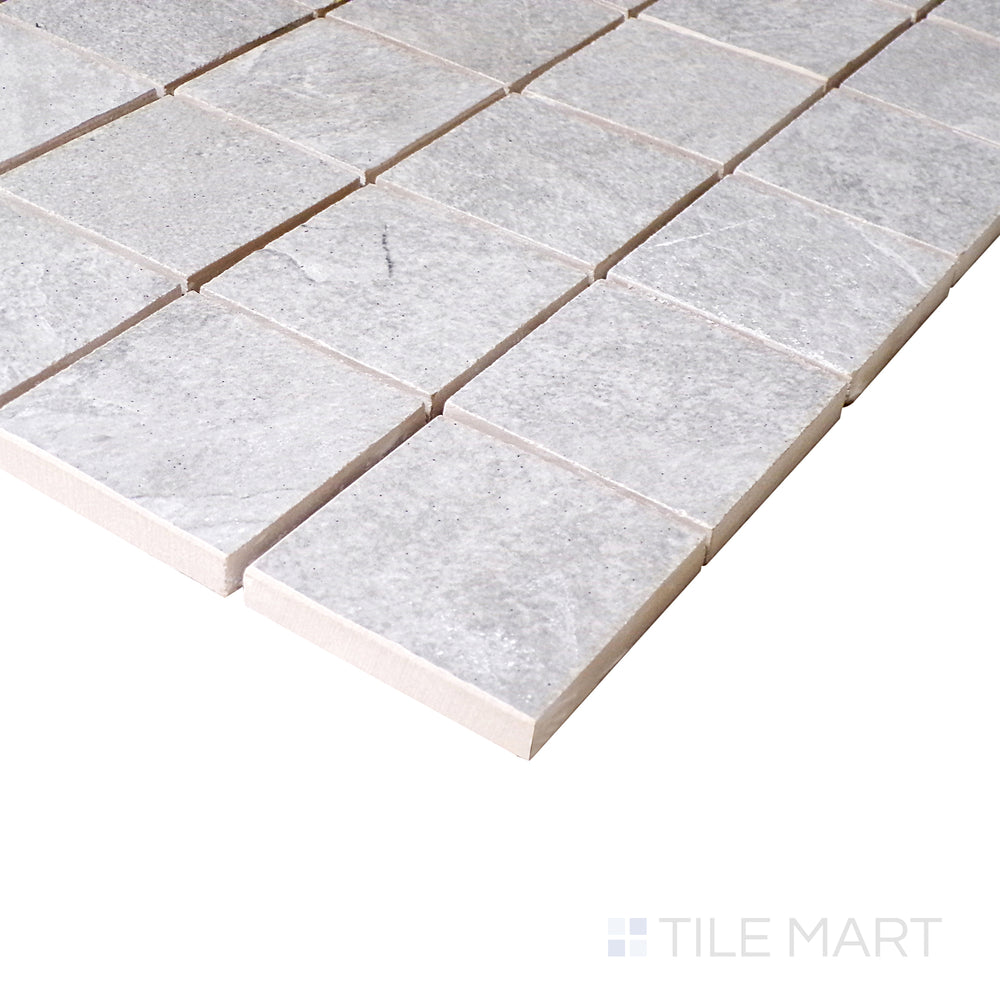 Seen from a slight angle, the silver mosaic squares reflect a subtle sheen, enhancing the structured layout of the porcelain surface.