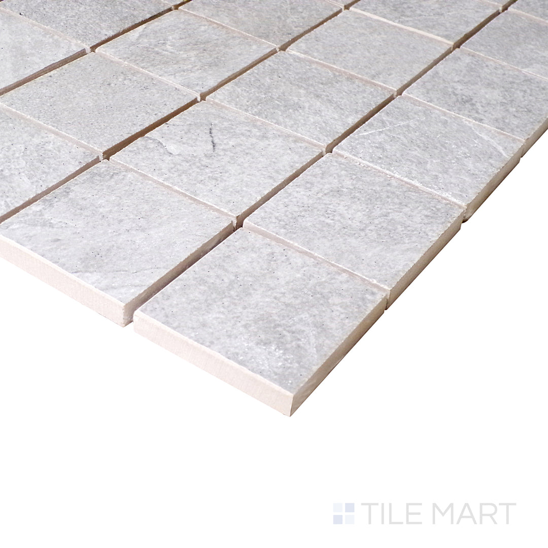 Seen from a slight angle, the silver mosaic squares reflect a subtle sheen, enhancing the structured layout of the porcelain surface.