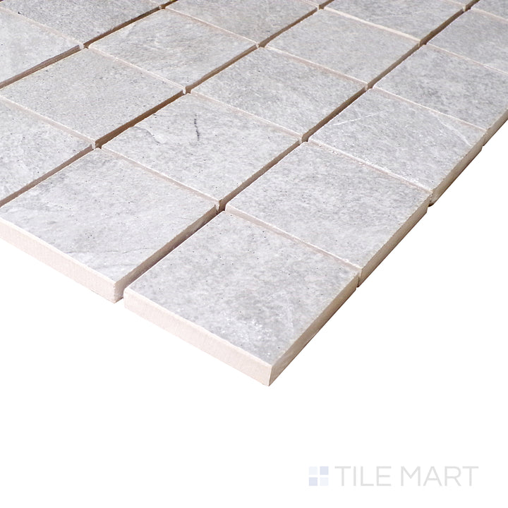 Seen from a slight angle, the silver mosaic squares reflect a subtle sheen, enhancing the structured layout of the porcelain surface.