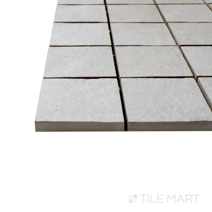 A corner perspective of the Ash White 2" square matte porcelain mosaic tile emphasizes its bright white finish and smooth matte surface, offering a clean and sophisticated look for walls and floors.