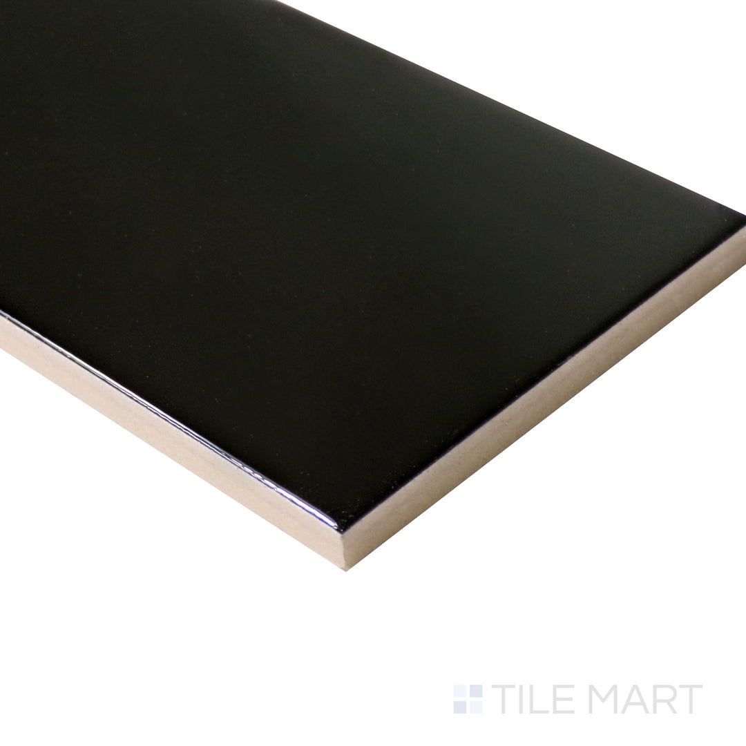 A glossy black ceramic tile is captured at an angle, accentuating its deep, polished sheen and modern aesthetic.