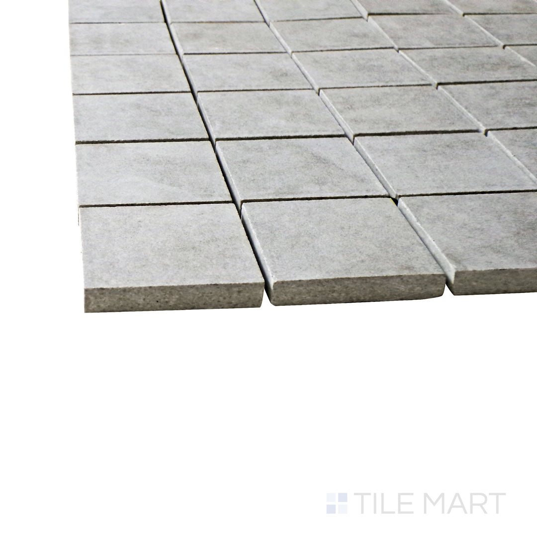 A corner perspective of the Creos Dorian 2" square matte porcelain mosaic tile emphasizes its deep gray tone and smooth matte finish, bringing a sleek and contemporary touch to tiled designs.