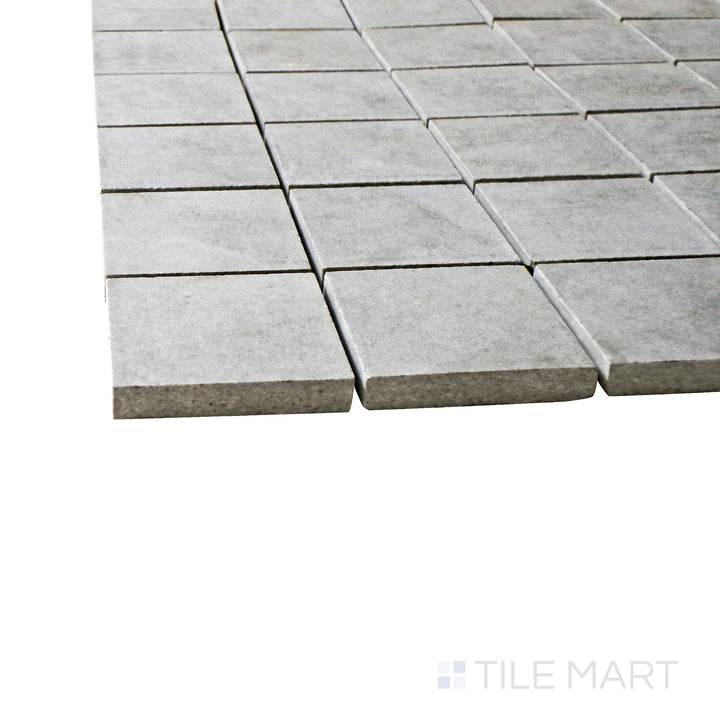 A corner perspective of the Creos Dorian 2" square matte porcelain mosaic tile emphasizes its deep gray tone and smooth matte finish, bringing a sleek and contemporary touch to tiled designs.