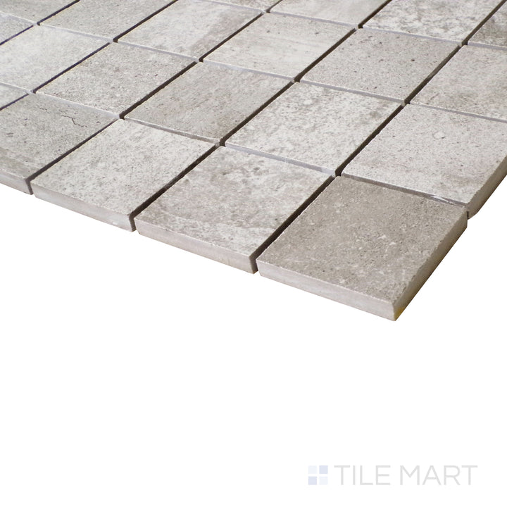 A zoomed-in view captures the sage green tones and precise square pattern, enhancing the tile’s matte surface.