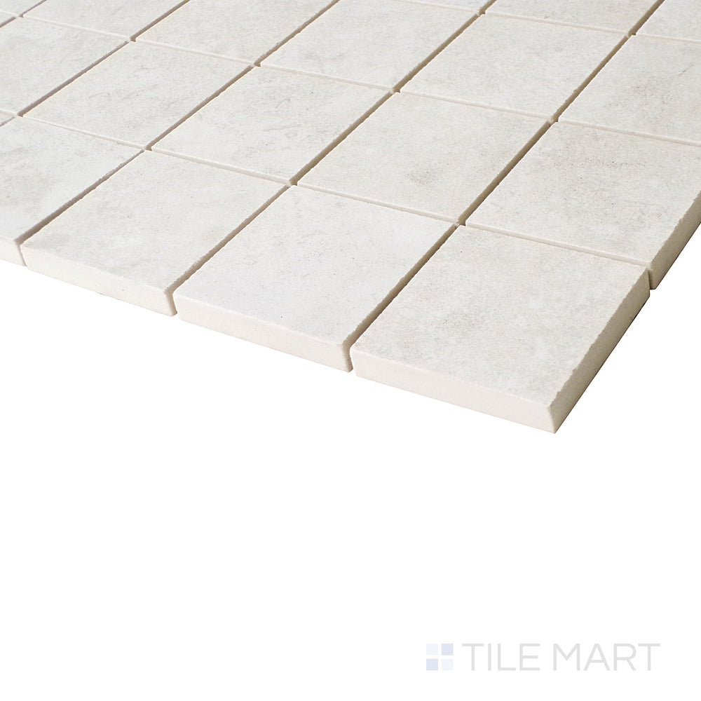 From an angled view, this ivory mosaic tile displays a harmonious blend of soft tones and a matte surface that enhances its modern simplicity.