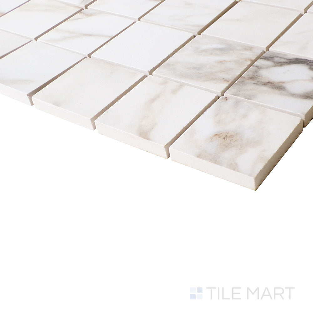 The Arabescato-inspired veining appears fluid in this angled shot, enhancing the polished finish and refined grid-like arrangement.