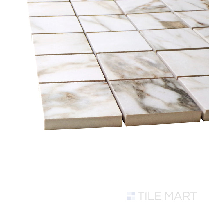 A corner shot of the Exotic Stone Cosmopolitan Arabescato 2" square polished porcelain mosaic tile highlights its luxurious white marble look with structured veining, adding sophistication to designs.