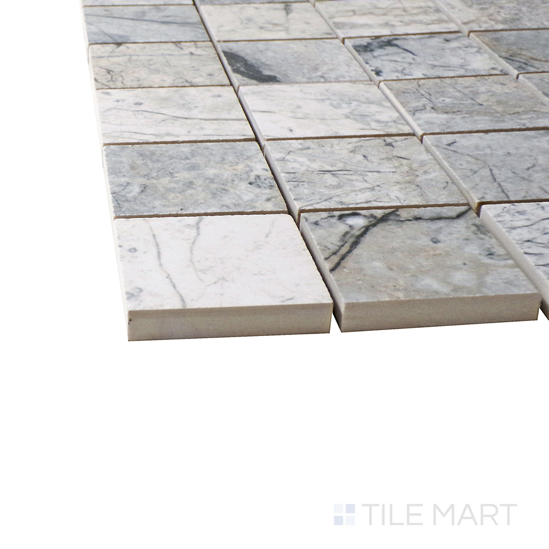 Captured from a corner angle, the Exotic Stone Cosmopolitan Mystic Grey 2" square polished porcelain mosaic tile showcases its rich gray tones and polished texture, creating a sleek and contemporary effect.