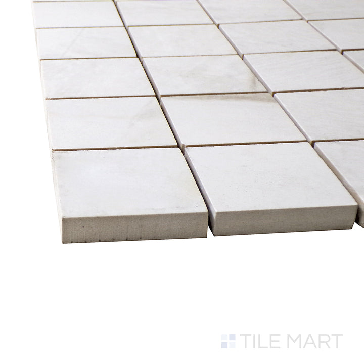A corner shot of the Exotic Stone Da Vinci White 2" square polished porcelain mosaic tile highlights its crisp white shade and polished sheen, offering a clean and modern look.
