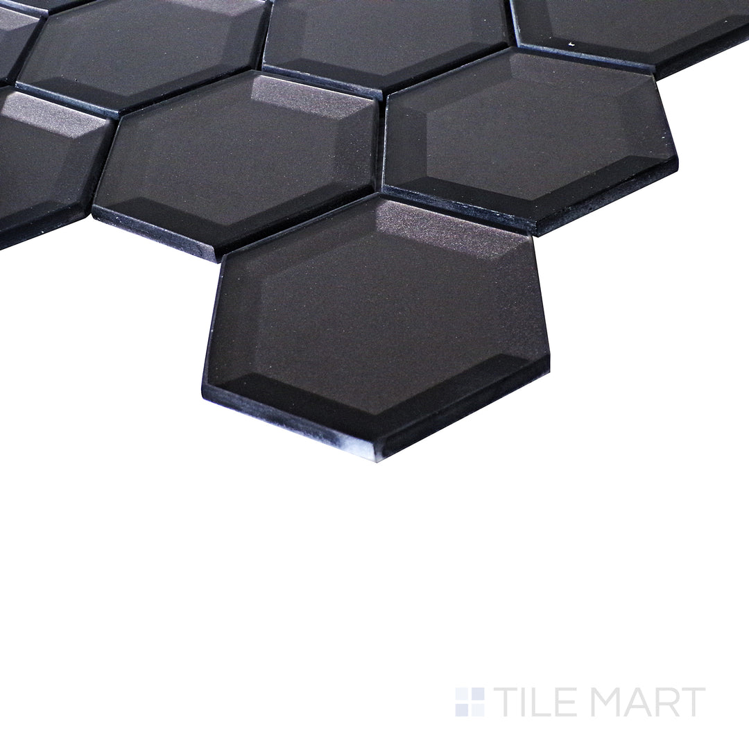 A dynamic angle captures the glossy depth of Bold Glass Black hexagon tiles, reflecting light for a modern, striking appeal.