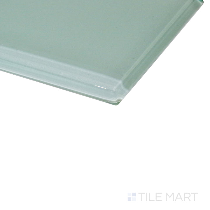 A subtle pastel green hue gleams under the light, with an angled shot highlighting the glossy glass texture.