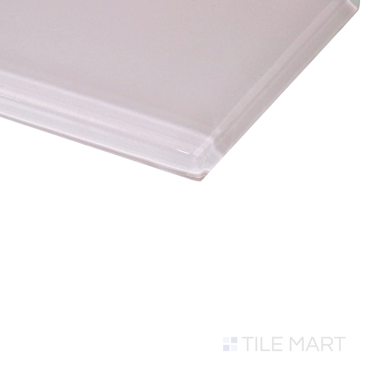 An angled perspective captures the delicate pastel pink glass tile, highlighting its glossy surface and soft light reflections.