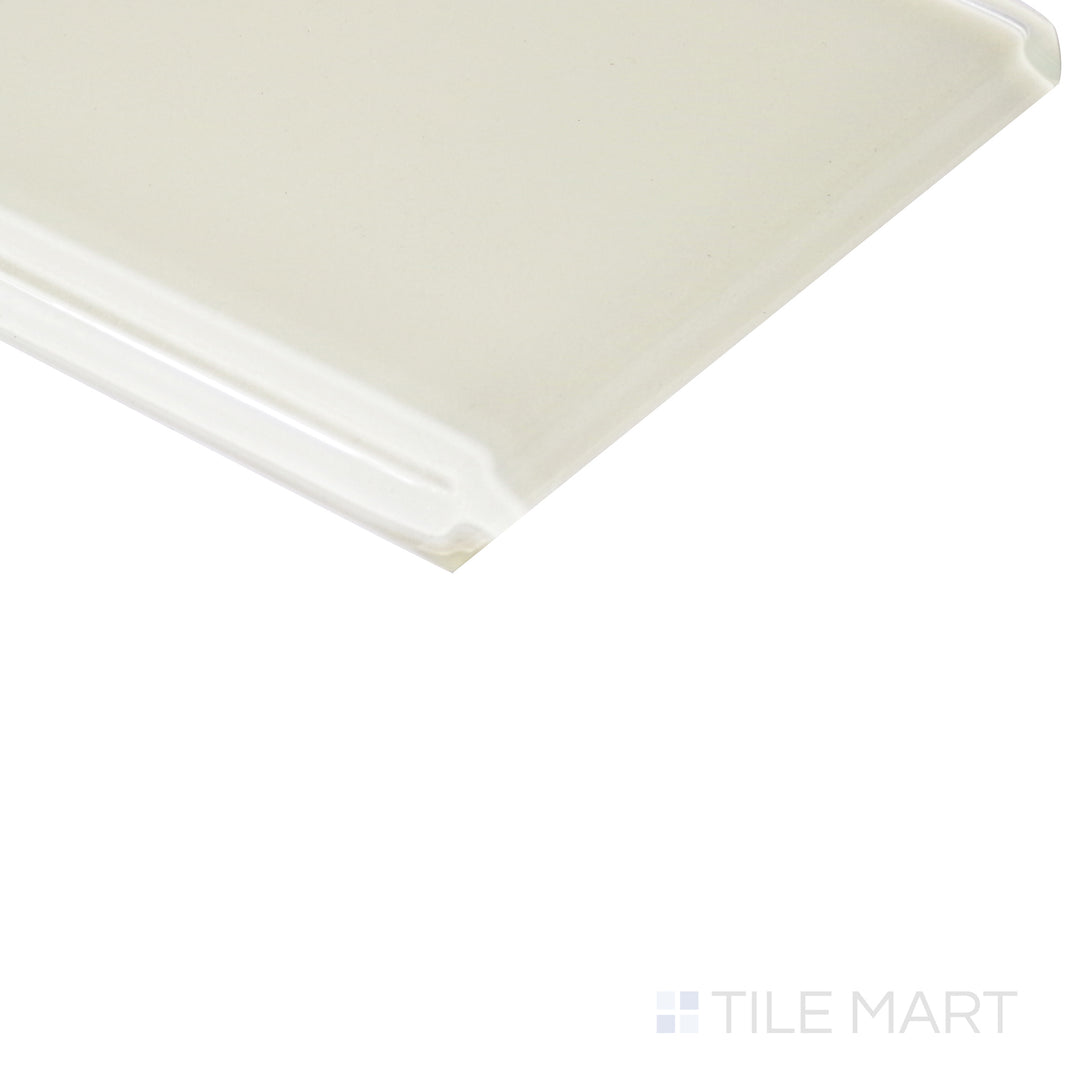 From an angled view, the pastel yellow glass tile reflects light beautifully, showcasing its polished surface with a radiant glow.