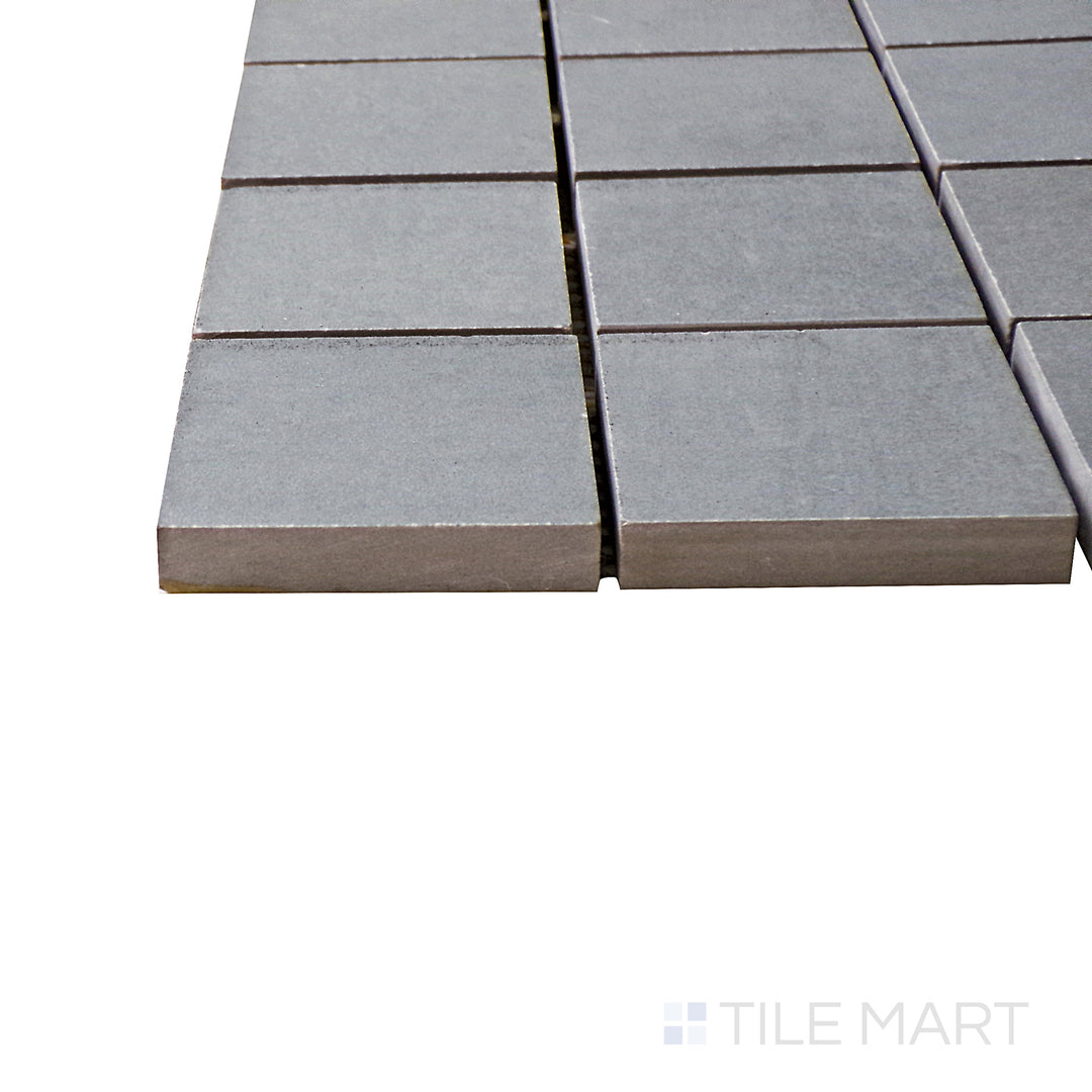 A corner shot of the Kadence Marengo 2" square matte porcelain mosaic tile highlights its rich gray hue and structured grid pattern, adding texture and depth to tiled surfaces.