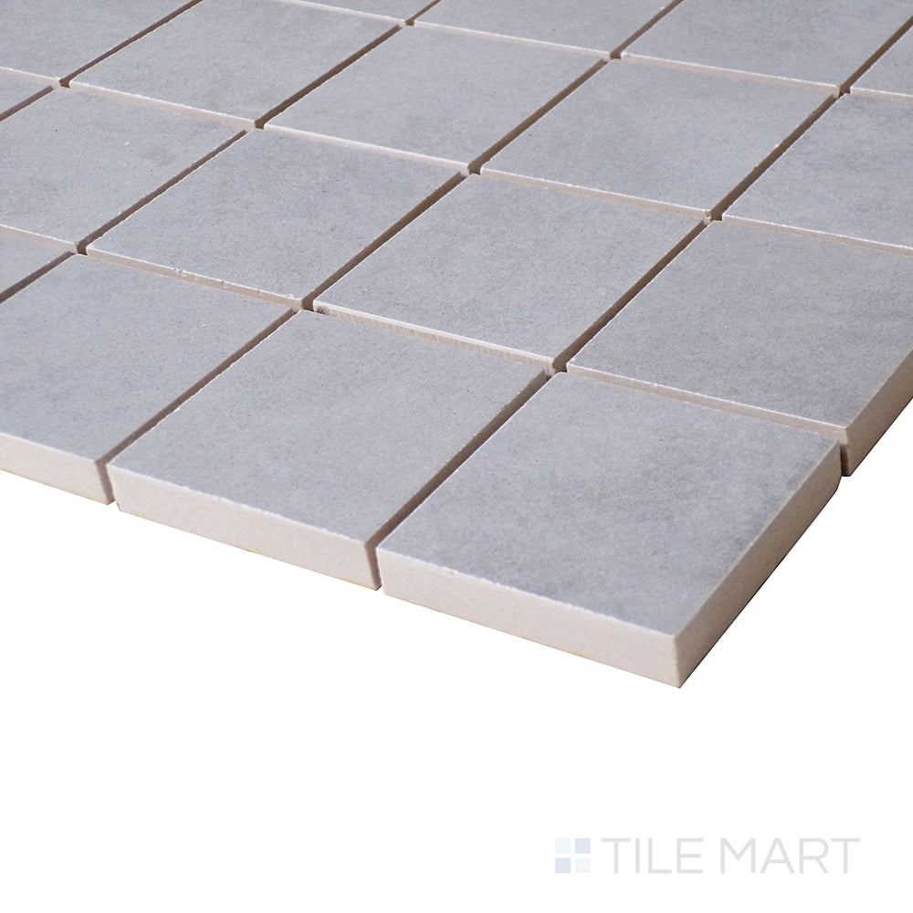 A side-angle view captures the smooth gray tones of this Gris mosaic, giving a contemporary feel to the matte finish.