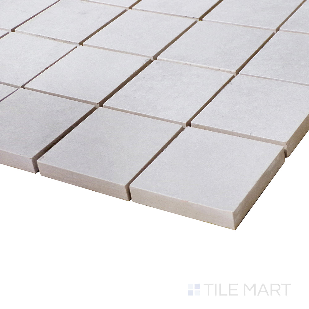 A close-up perspective highlights the pearlescent undertones of this Perla matte square mosaic, offering a soft, elegant look.