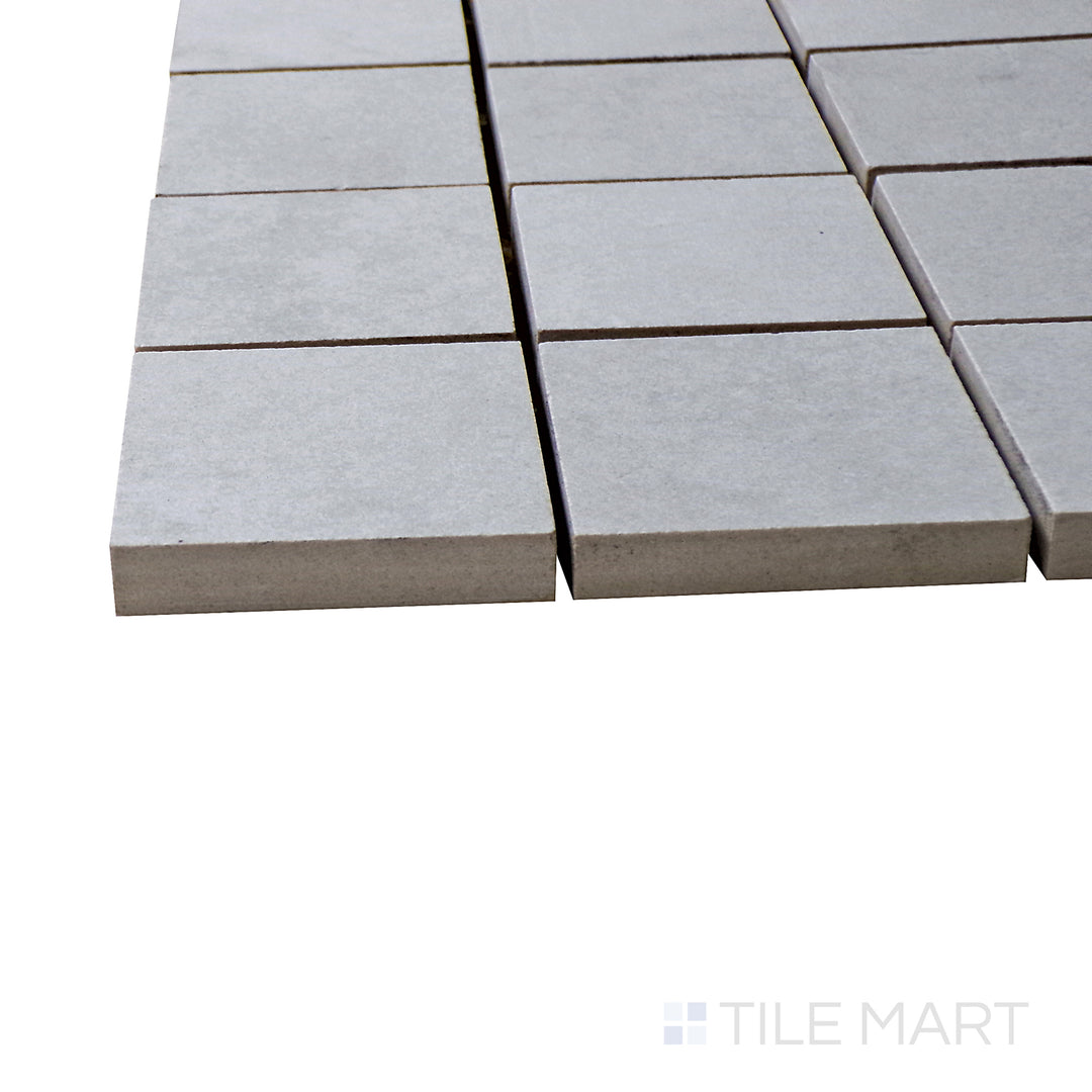 A corner shot of the Kadence Perla 2" square matte porcelain mosaic tile highlights its warm pearl-gray tones and matte texture, delivering a sophisticated and elegant touch.