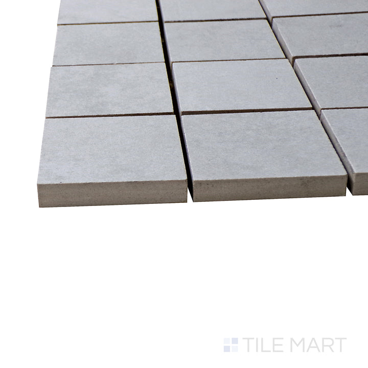 A corner shot of the Kadence Perla 2" square matte porcelain mosaic tile highlights its warm pearl-gray tones and matte texture, delivering a sophisticated and elegant touch.