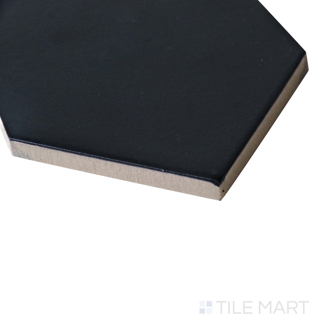 A side-angle close-up captures the deep, bold black tones of this matte porcelain tile, emphasizing its clean lines and smooth texture.