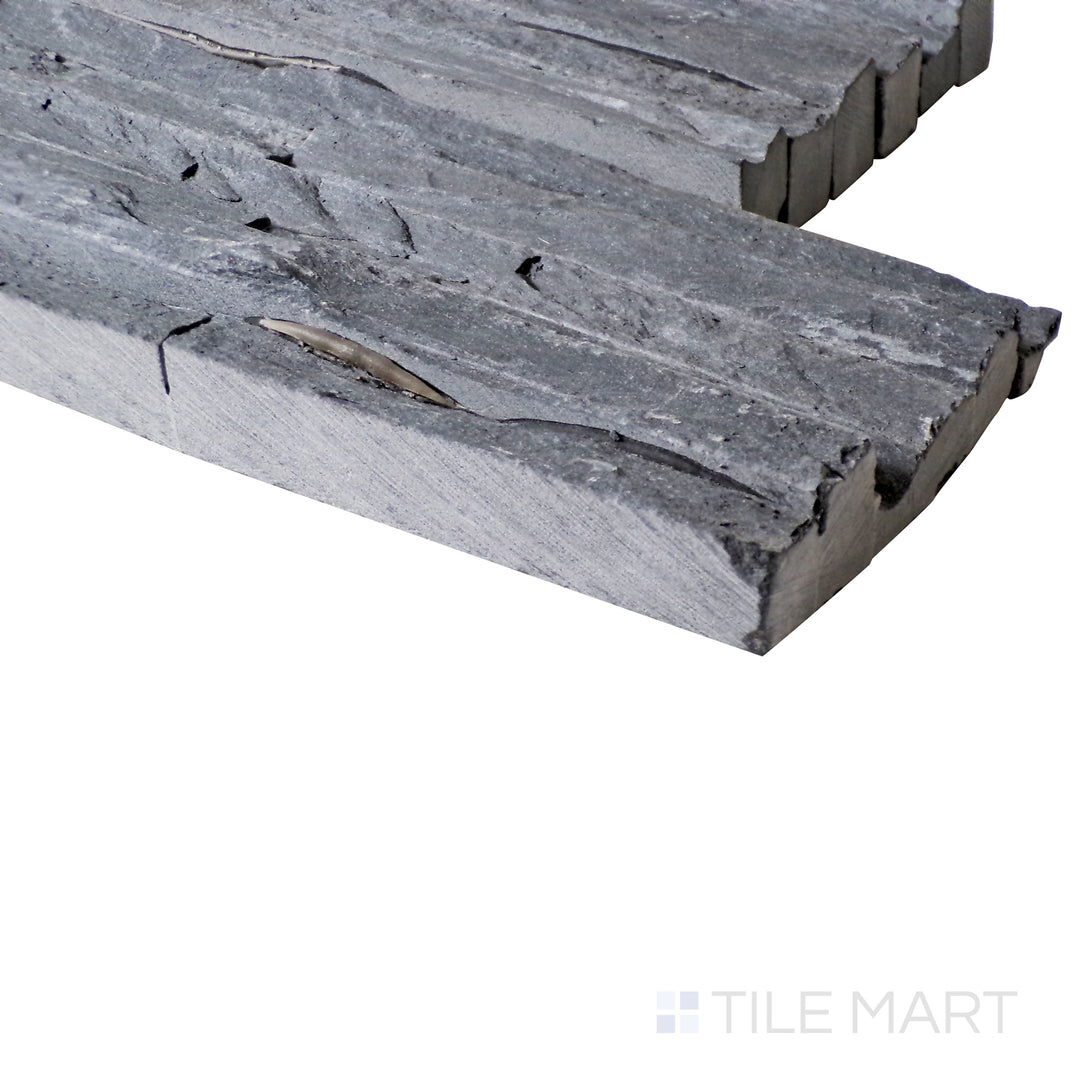 An angled perspective enhances the rugged texture and deep charcoal tones of this natural stone, showcasing its organic layered surface.