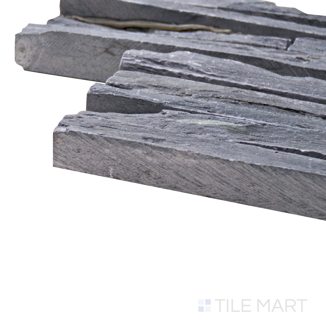 Captured from a corner angle, the Contemporary Mini Ledgestone Charcoal 6x24 natural stone tile showcases its deep charcoal tones and rugged texture, delivering a bold and earthy aesthetic.