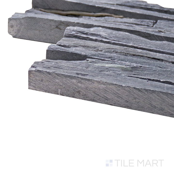 Captured from a corner angle, the Contemporary Mini Ledgestone Charcoal 6x24 natural stone tile showcases its deep charcoal tones and rugged texture, delivering a bold and earthy aesthetic.