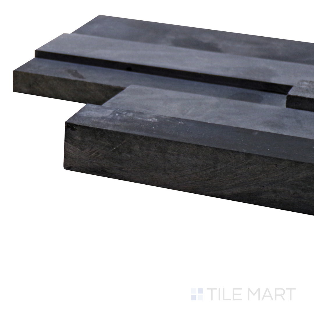 Captured from a corner angle, the Modern Ledgestone Basalt Black 6x24 porcelain tile showcases its deep black shade and realistic stone texture, adding a bold and sophisticated touch.
