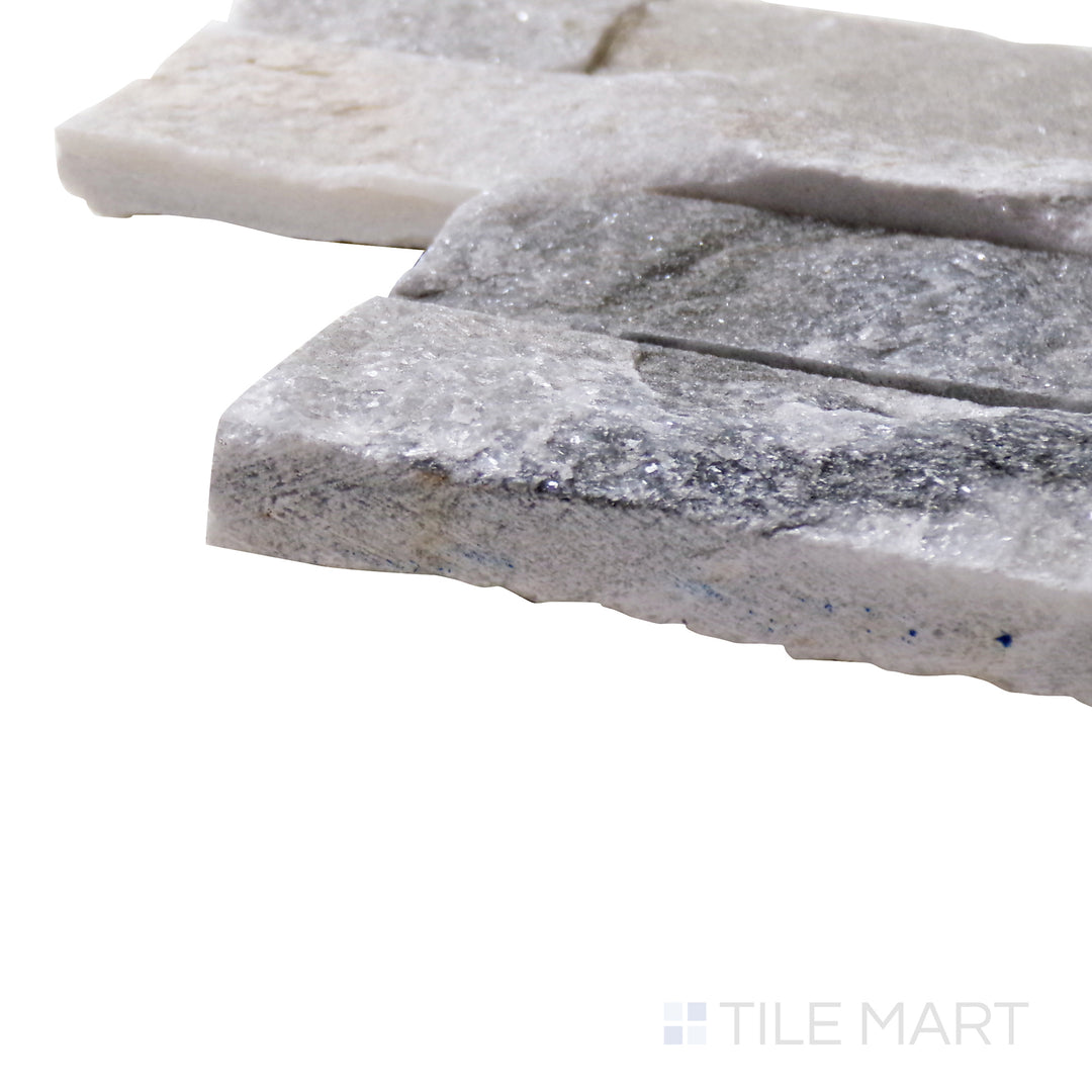 A corner shot of the Natural Splitface Stackstone Panels Alaska Grey 6x24 highlights its textured gray stone surface, creating a rugged and contemporary aesthetic for walls and facades.