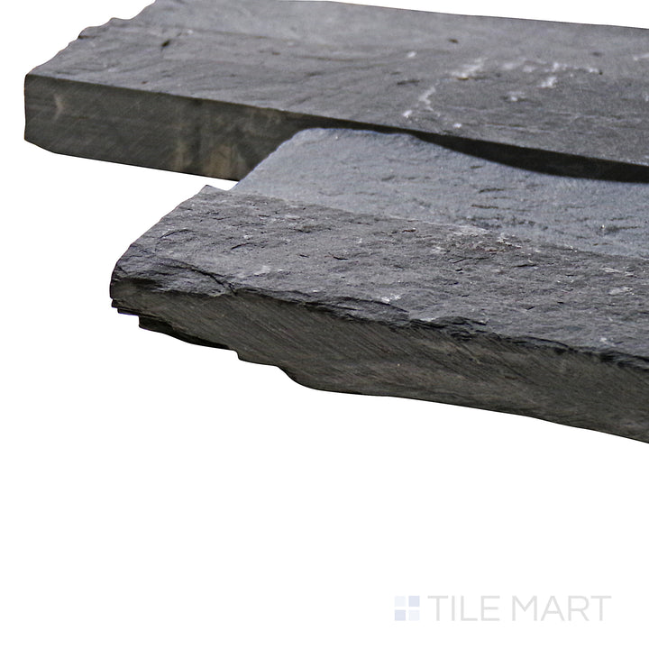Captured from a corner angle, the Natural Splitface Stackstone Panels Midnight 6x24 showcases its deep charcoal tones and rough stone texture, perfect for bold and dramatic designs.