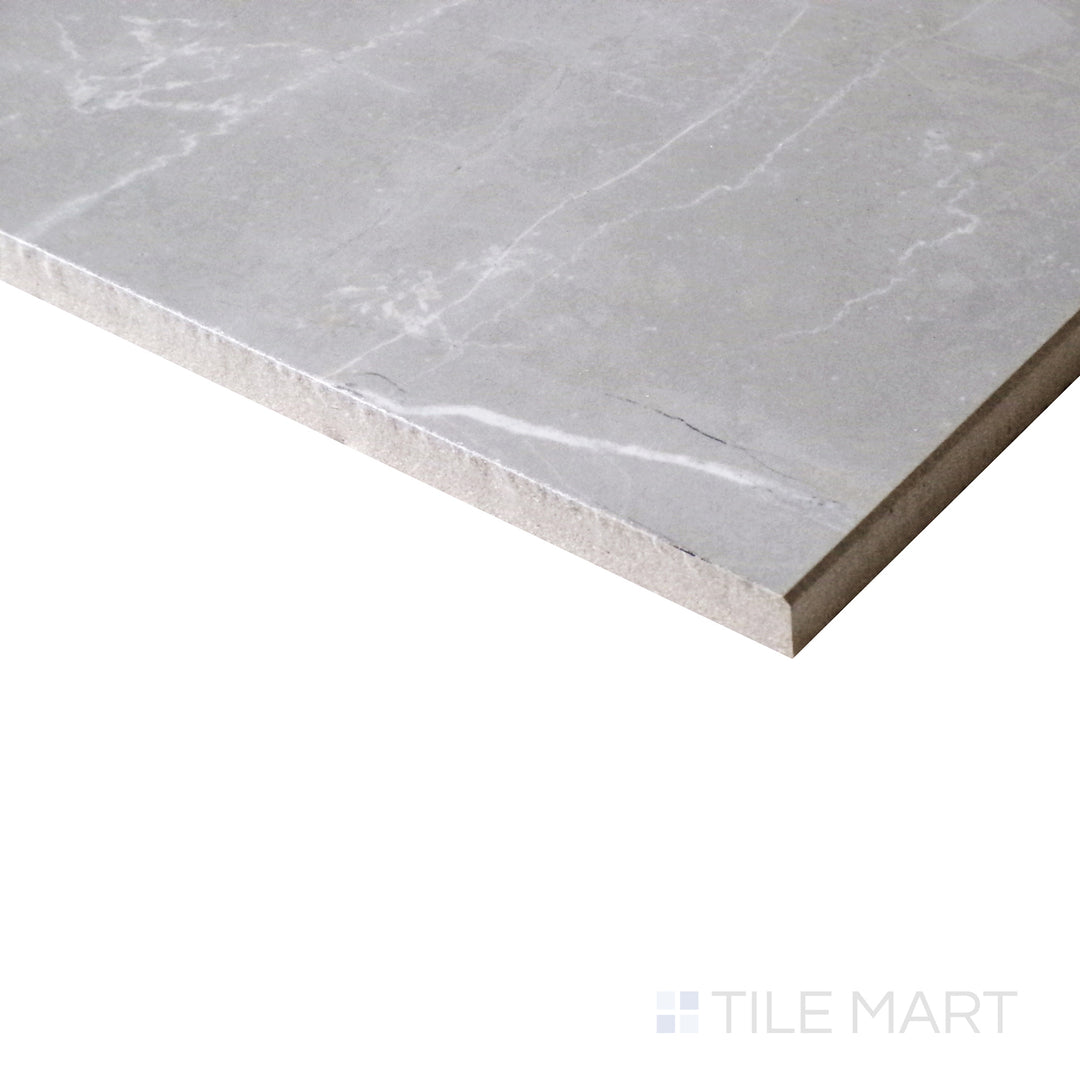 A close-up from an angle highlights the soft, smoky tones of Amani Grey porcelain, with a reflective polished finish that enhances its depth.