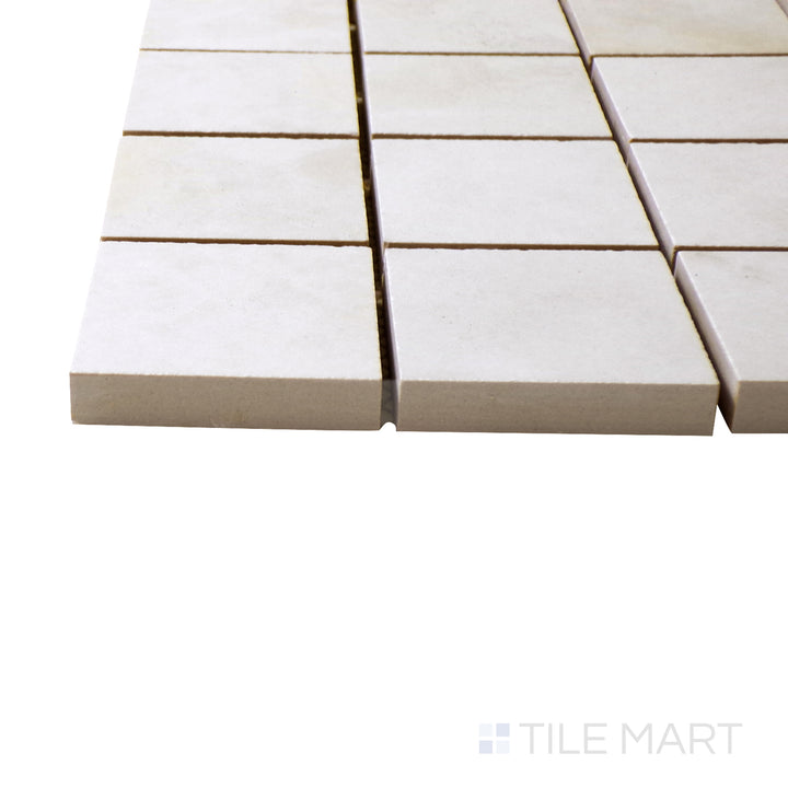 A corner perspective of the Luxury Kristalus White 2" square polished porcelain mosaic tile emphasizes its pristine white shade and glossy texture, creating a classic and elegant mosaic look.