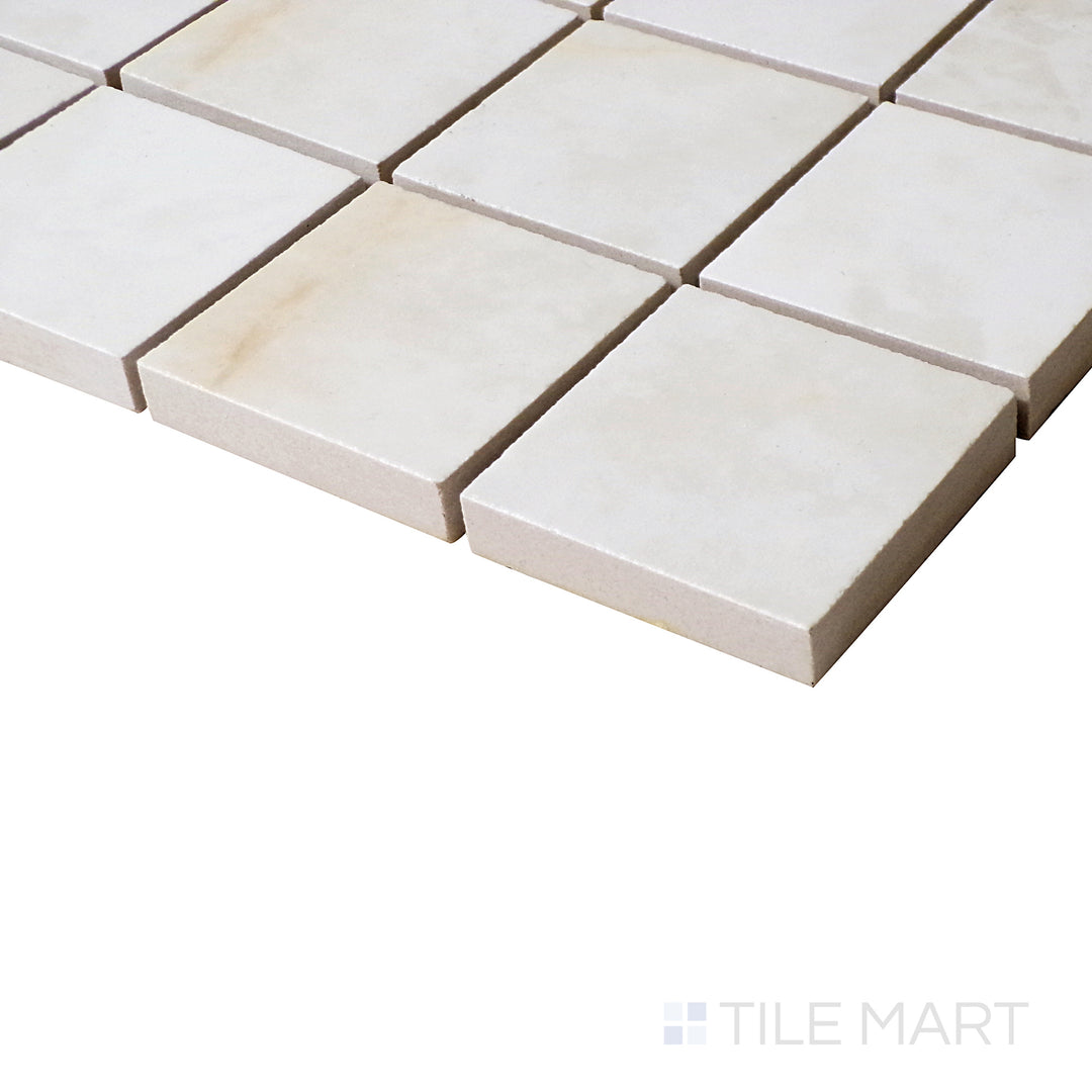 Luxury Kristalus Cream 2" Square Polished Porcelain Mosaic in an angled shot, highlighting its warm cream shade and polished sheen.