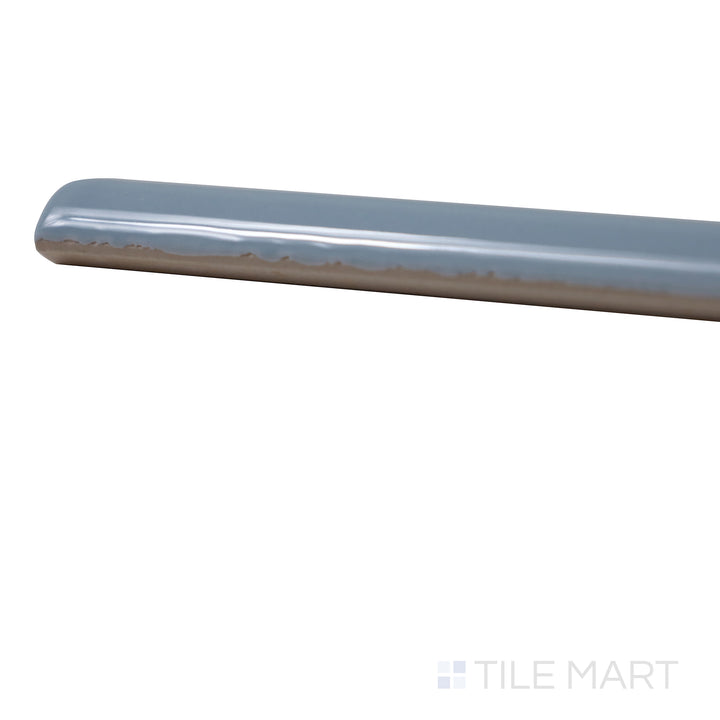 Angled view of Manhattan Ceramic 7th Ave 0.5x12 glossy demi-bullnose tile showing rounded edge and reflective finish