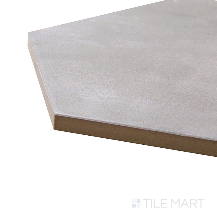 A corner shot of the Meraki Base Gris 8" hexagon matte porcelain tile highlights its soft gray tones and modern hexagonal shape, making it a versatile design choice.