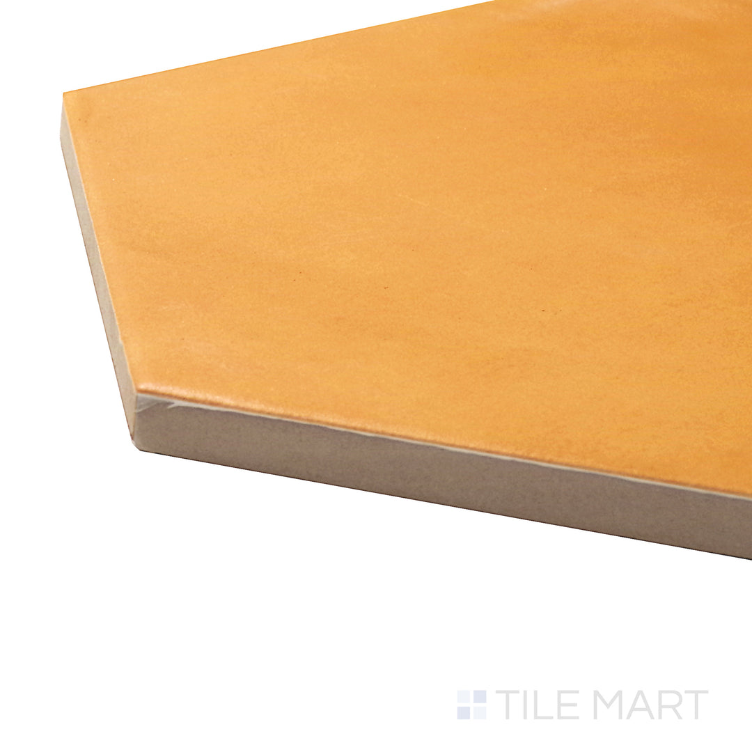 Captured from a corner angle, the Meraki Base Mostaza 8" hexagon matte porcelain tile showcases its warm mustard-yellow hue and matte finish, adding a vibrant touch.