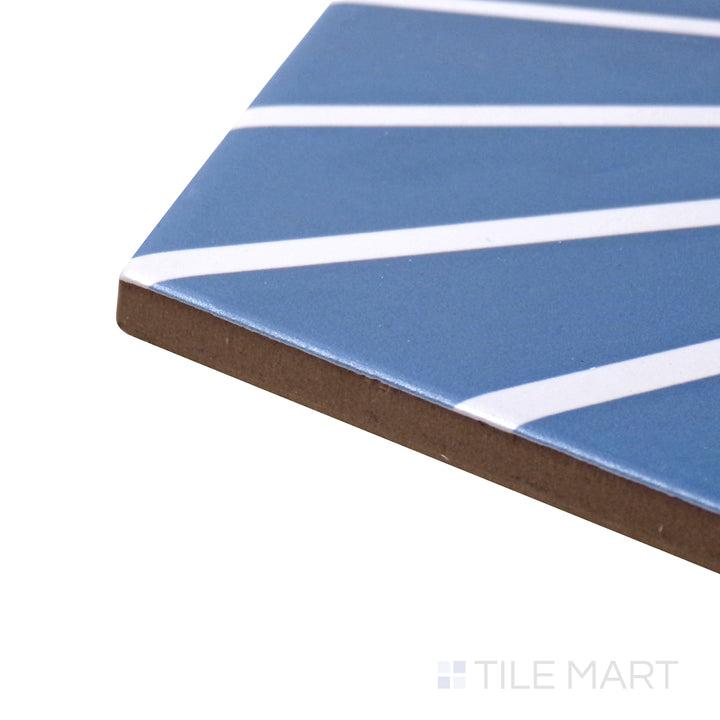 A corner shot of the Meraki Even Deco Azul 8" hexagon matte porcelain tile highlights its vibrant blue decorative design and matte texture, making it a standout feature.