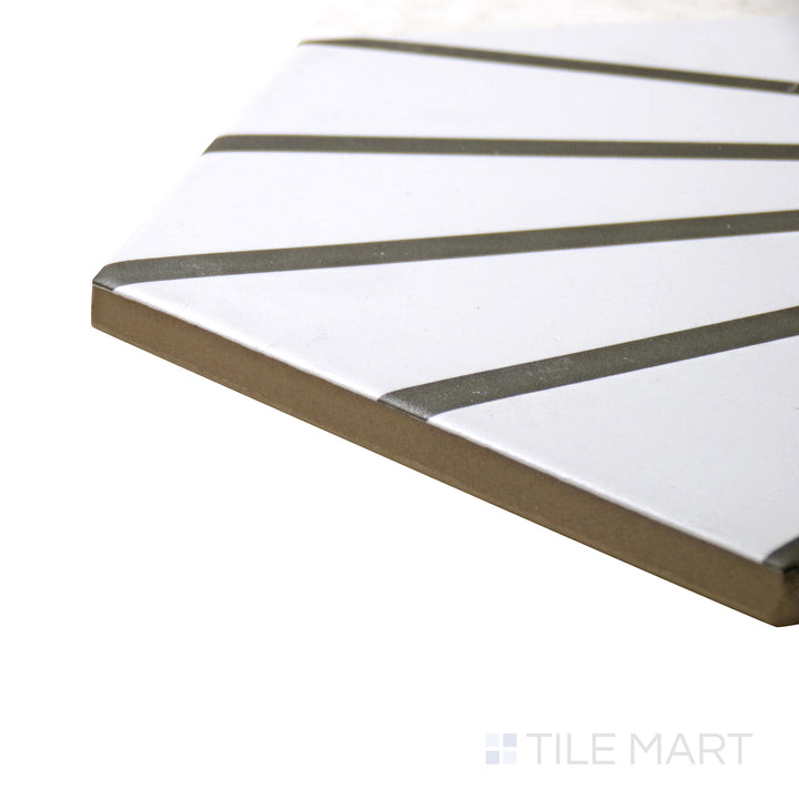 Captured from a corner angle, the Meraki Even Deco Blanco 8" hexagon matte porcelain tile showcases its intricate white pattern and geometric shape, offering a classic yet modern appeal.