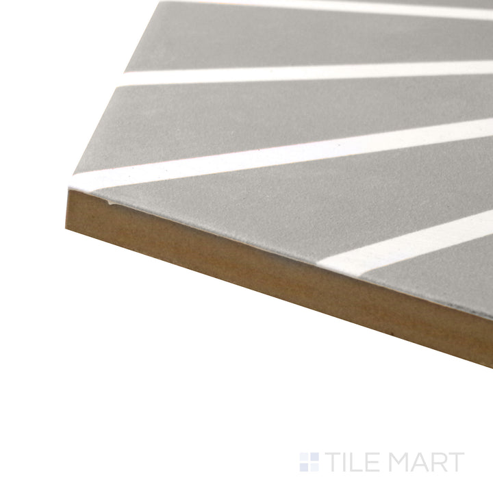 A corner perspective of the Meraki Even Deco Gris 8" hexagon matte porcelain tile emphasizes its soft gray tones and decorative print, creating a stylish and neutral design.