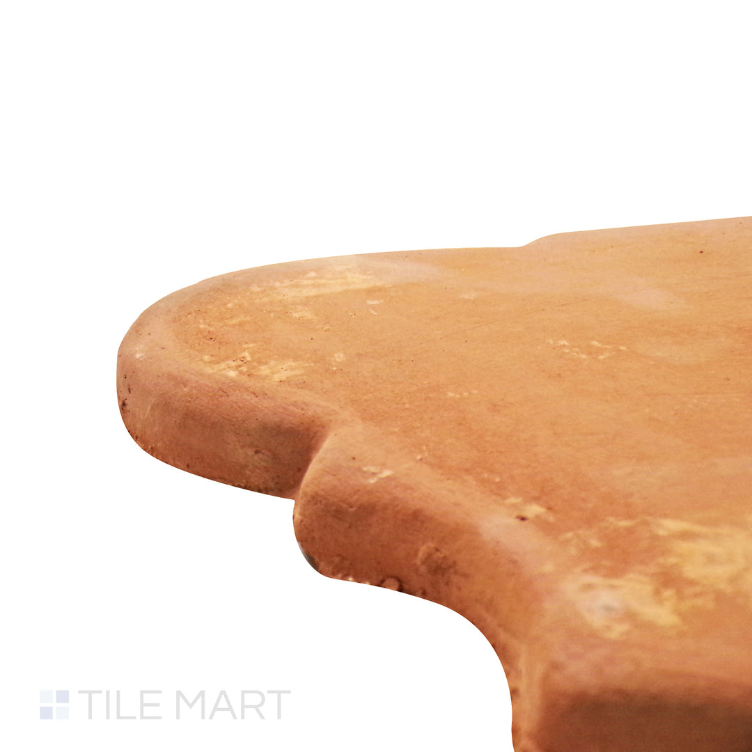 A corner perspective of the Lincoln Pavers Red 9x11 San Felipe natural terracotta tile emphasizes its uniquely curved edges and rustic finish, offering an Old World charm to any setting.