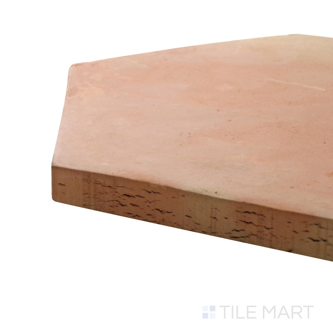 Captured from a corner angle, the Saltillo Salmon 12" hex natural terracotta tile showcases its unique handcrafted imperfections and earthy color, adding depth and character to any space.