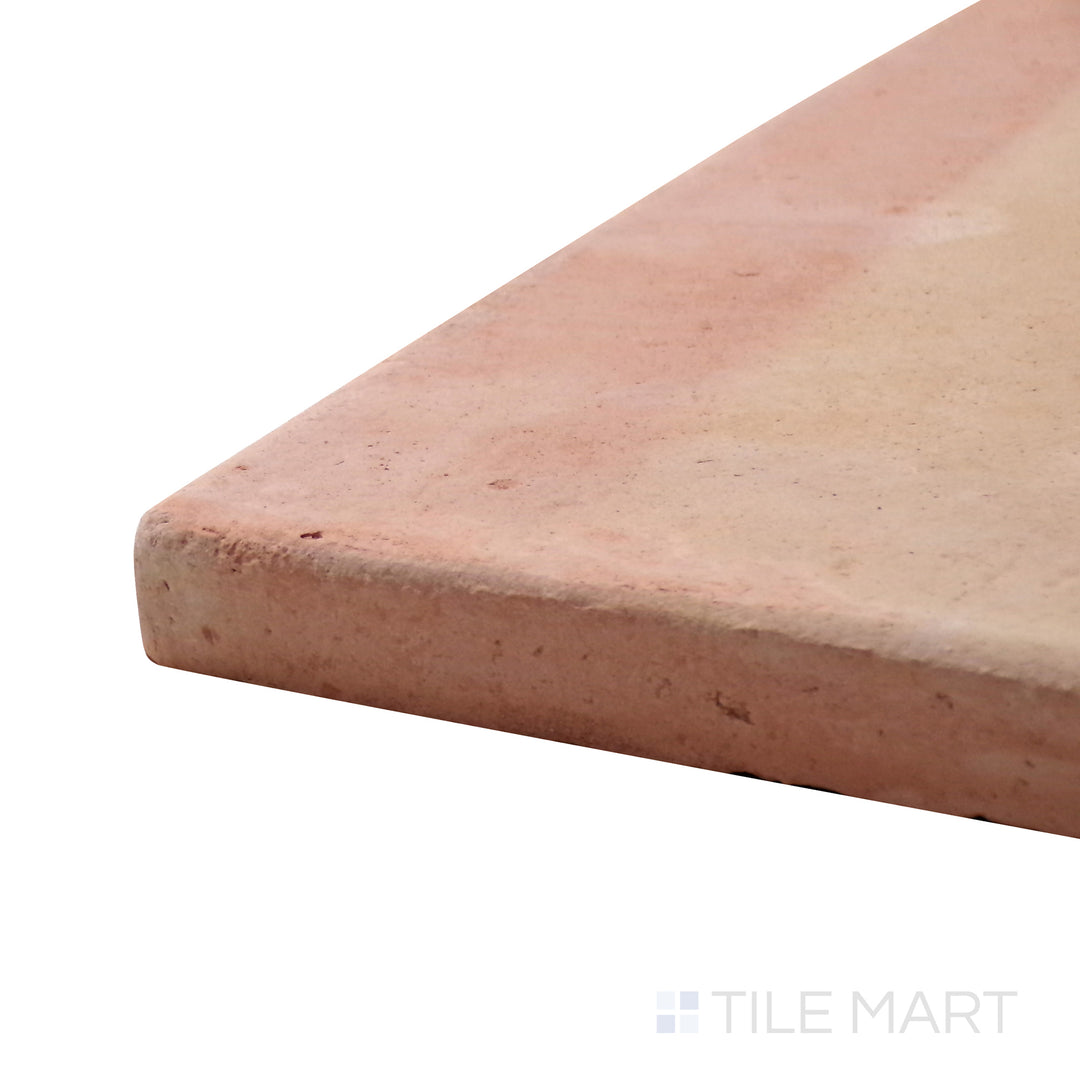 A corner perspective of the Saltillo Salmon 12x12 round edge natural terracotta tile emphasizes its handcrafted edges and deep salmon color, adding warmth to flooring and walls.