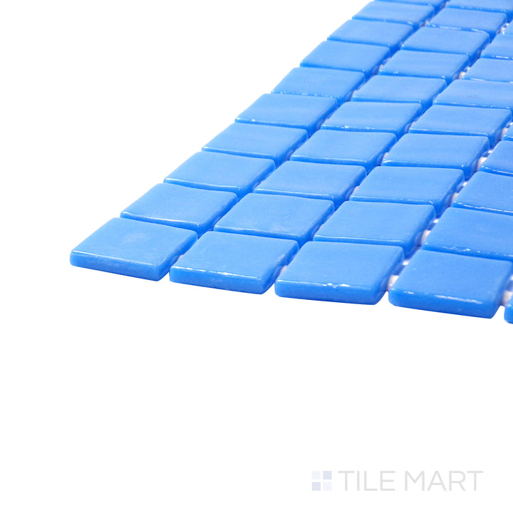 A corner shot of the Lisa Azul Celeste 1" square glossy glass mosaic tile highlights its vibrant sky-blue shade and glossy texture, perfect for brightening up accent walls and backsplashes.