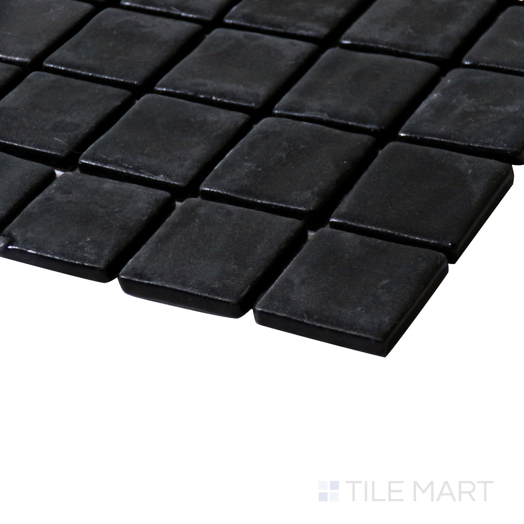 Angled close-up capturing the bold elegance of Natureglass Malla Black 1" square matte glass mosaic.