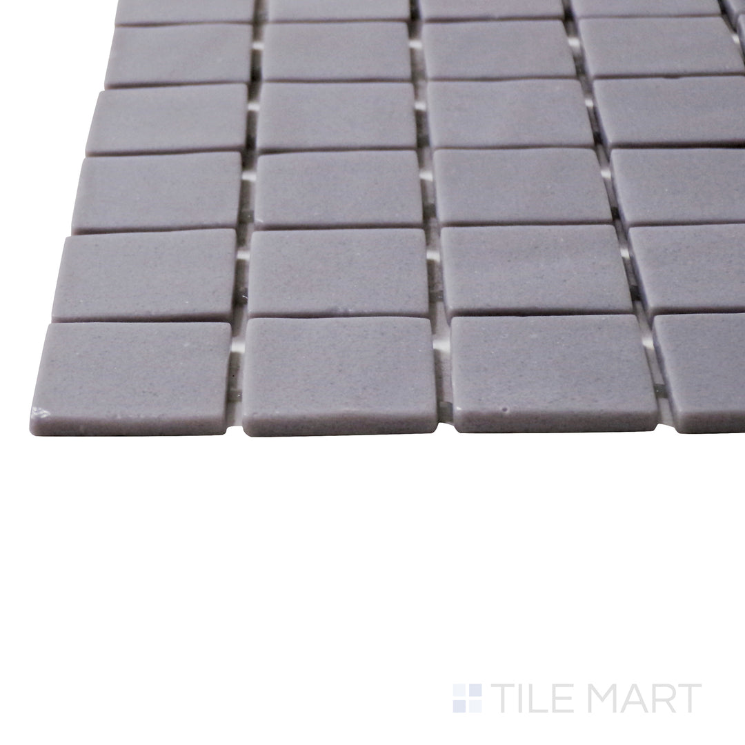 A corner shot of the Natureglass Malla Grey 1" square matte glass mosaic tile highlights its soft gray color and matte texture, creating a sleek and versatile design.