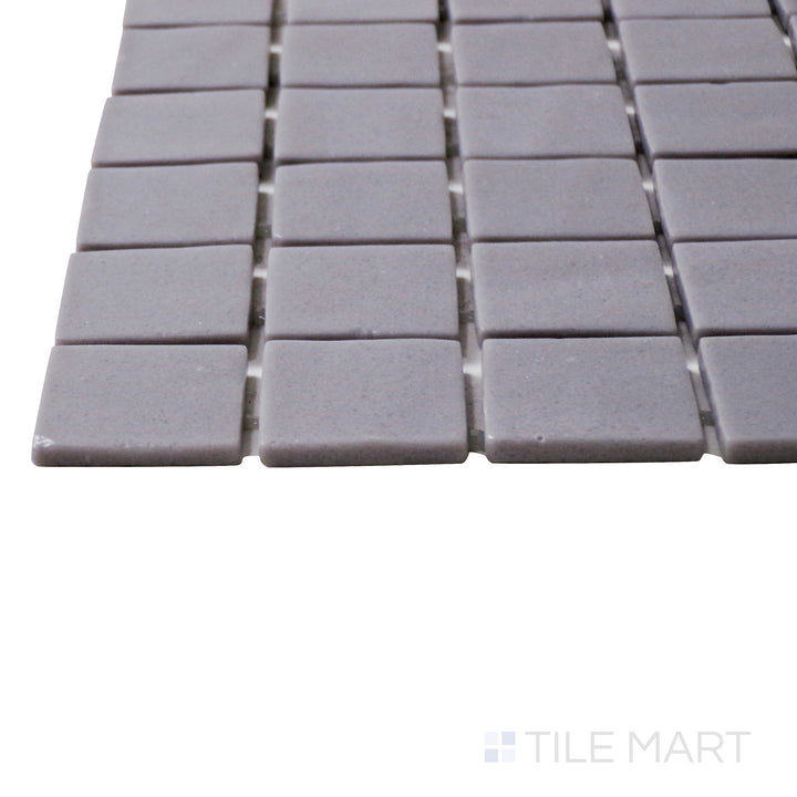 A corner shot of the Natureglass Malla Grey 1" square matte glass mosaic tile highlights its soft gray color and matte texture, creating a sleek and versatile design.