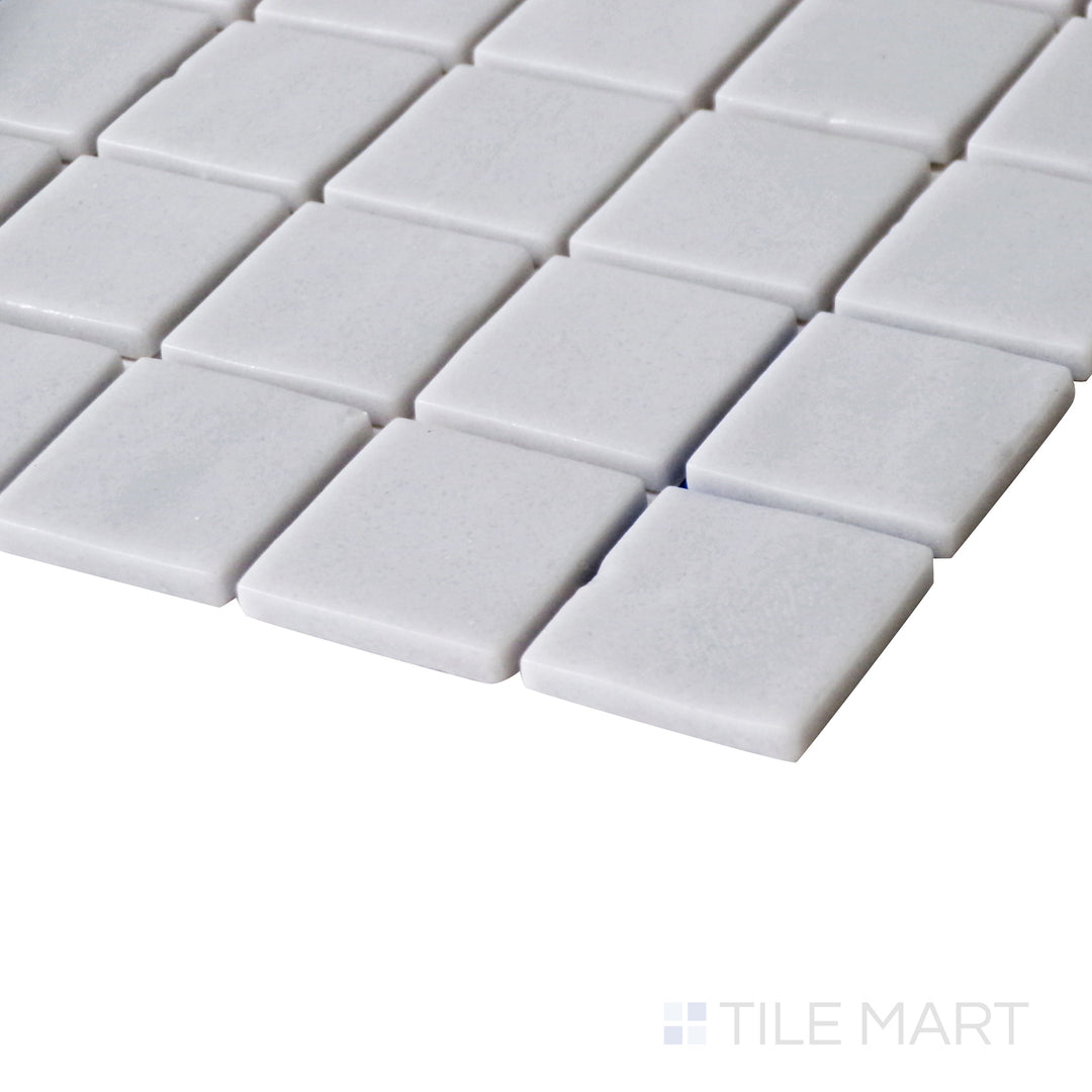 Tilted shot showcasing the soft, contemporary finish of Natureglass Malla Smooth Grey 1" square matte glass mosaic.