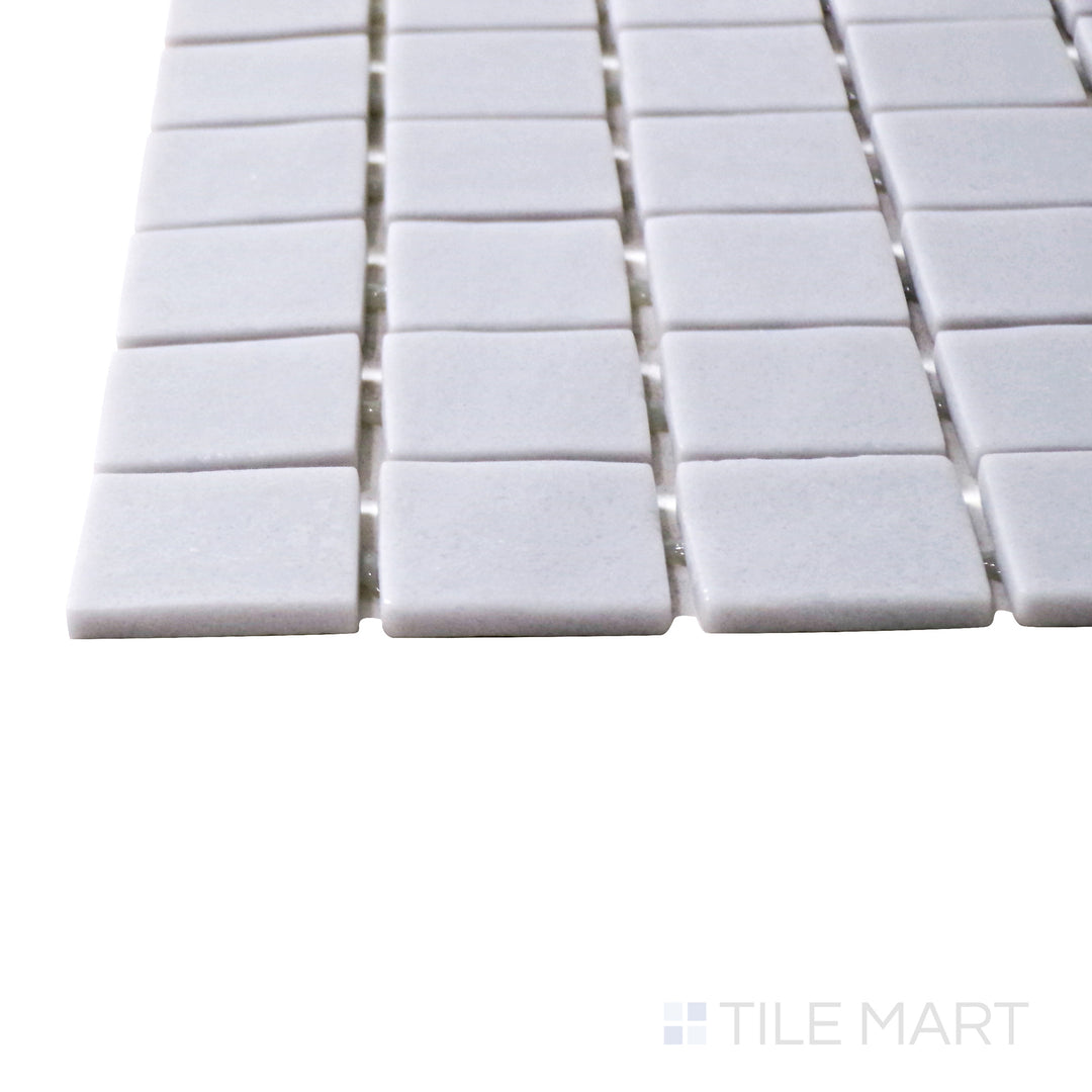 Captured from a corner angle, the Natureglass Malla Smooth Grey 1" square matte glass mosaic tile showcases its refined matte surface and neutral gray tone, perfect for contemporary interiors.