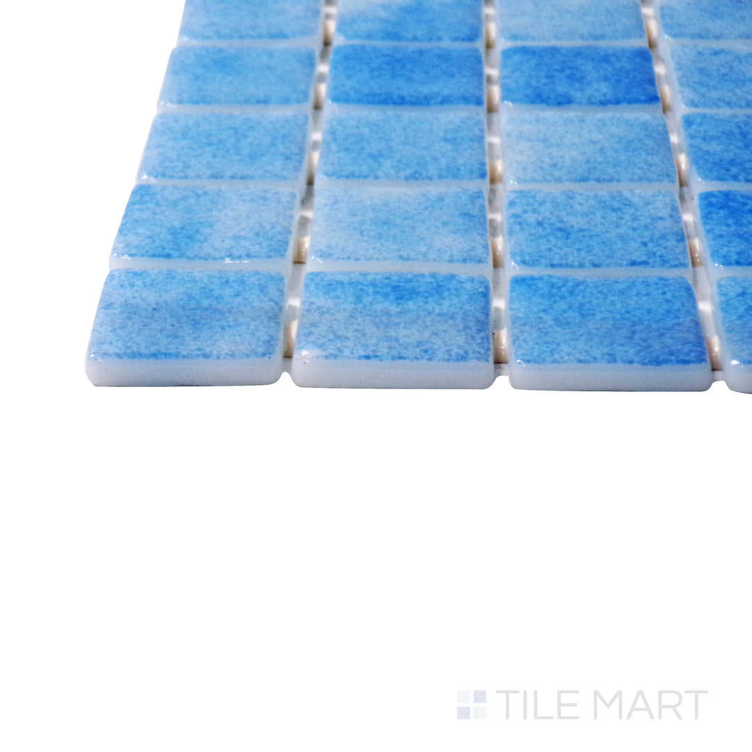 A corner shot of the Nieve Celeste 1" square glossy glass mosaic tile highlights its icy blue tones and polished surface, creating a refreshing and luminous accent.