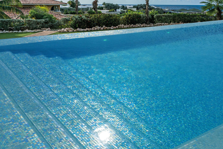 A tranquil and coastal-inspired setting with Opalescent Celeste Azul 1" square glossy glass mosaic, reflecting light for an open and airy feel.